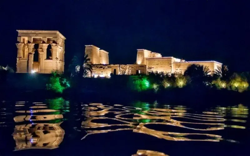 Night crossing to Philae Temple Aswan — motorboat to the illuminated Isis temple